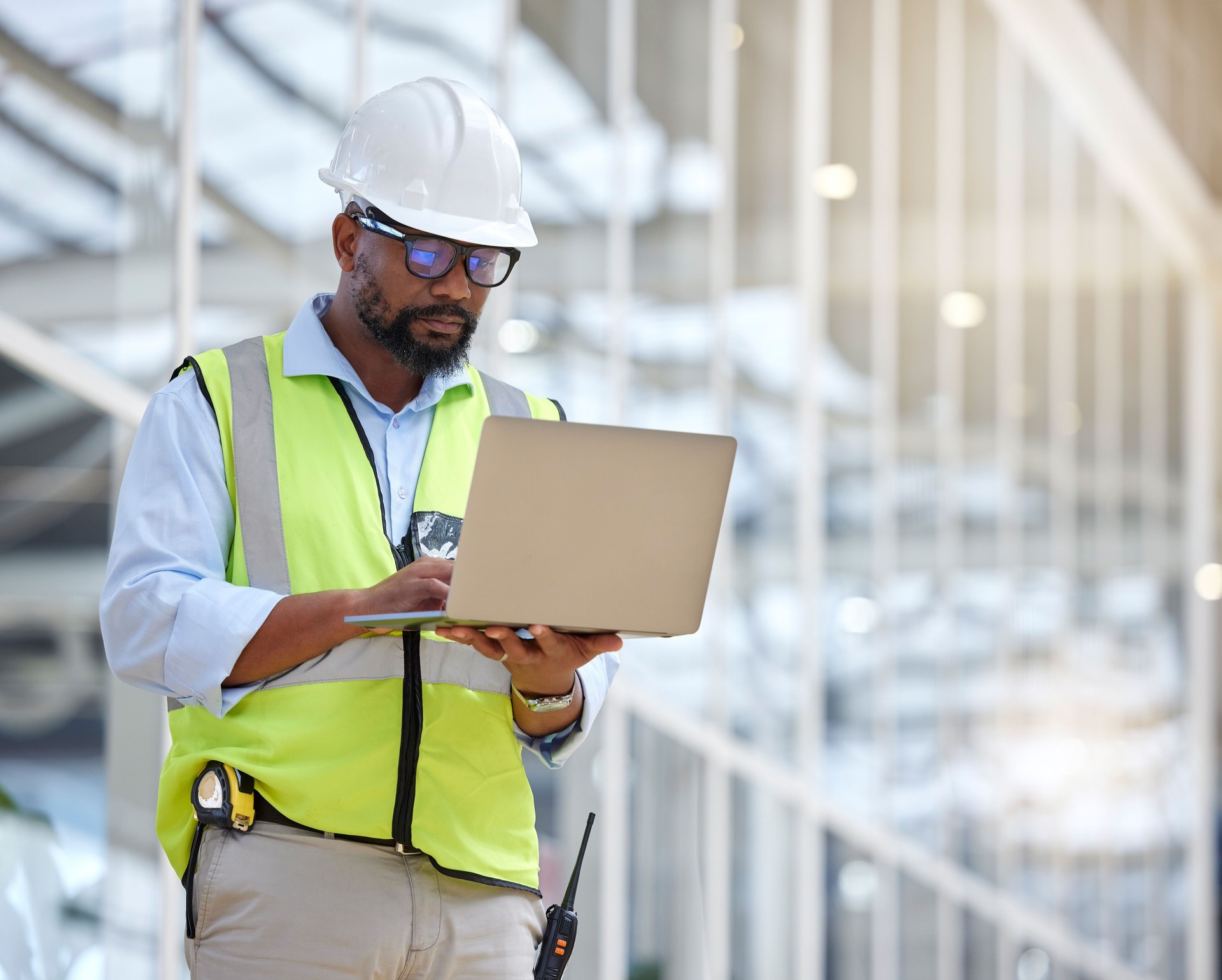 Arquitectura, investigación y laptop con hombre negro en almacén para ingeniería, edificación y diseño. Tecnología, planificación y digital con enfoque de contratista para la gestión de proyectos y gráficos
